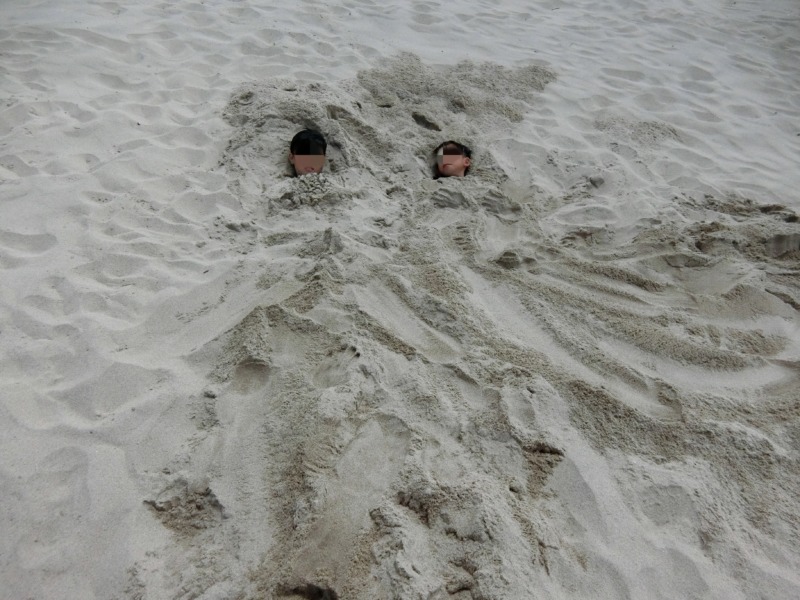 人を砂浜に埋めてもらった写真