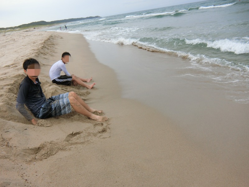 砂浜に座り海を堪能している息子達