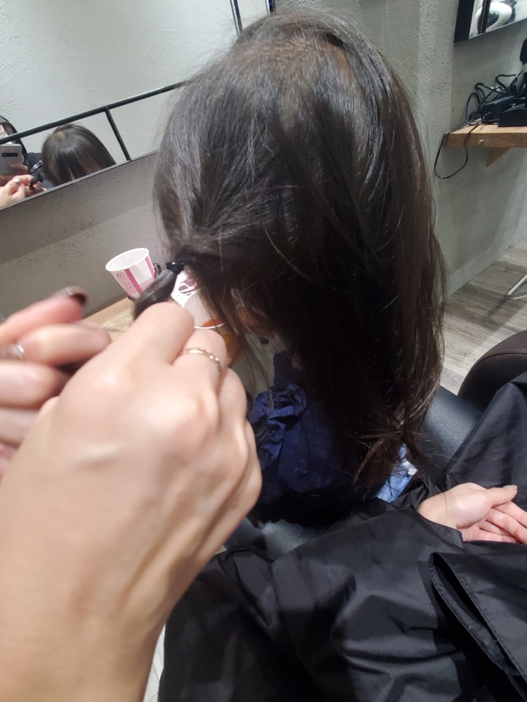 美容師に娘の髪型アレンジをして貰っている写真